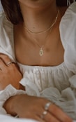 woman in white off shoulder dress wearing silver necklace