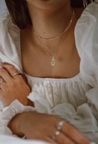 woman in white off shoulder dress wearing silver necklace