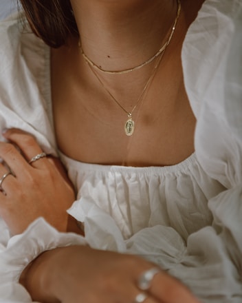 woman in white off shoulder dress wearing silver necklace