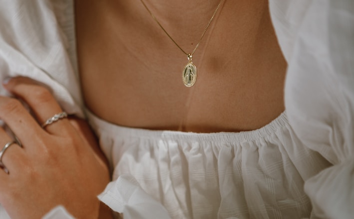 woman in white off shoulder dress wearing silver necklace