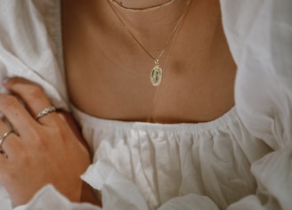 woman in white off shoulder dress wearing silver necklace