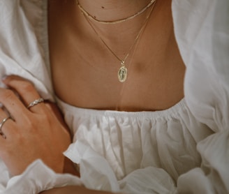 woman in white off shoulder dress wearing silver necklace