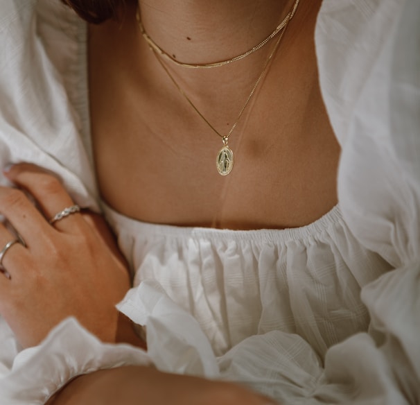 woman in white off shoulder dress wearing silver necklace