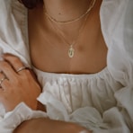 woman in white off shoulder dress wearing silver necklace