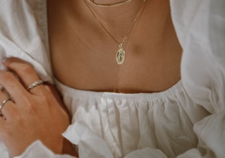 woman in white off shoulder dress wearing silver necklace