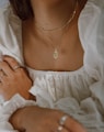 woman in white off shoulder dress wearing silver necklace