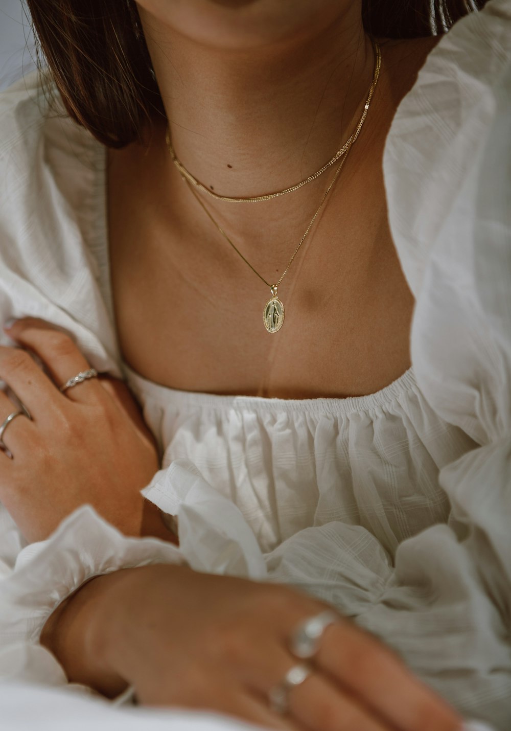 woman in white off shoulder dress wearing silver necklace