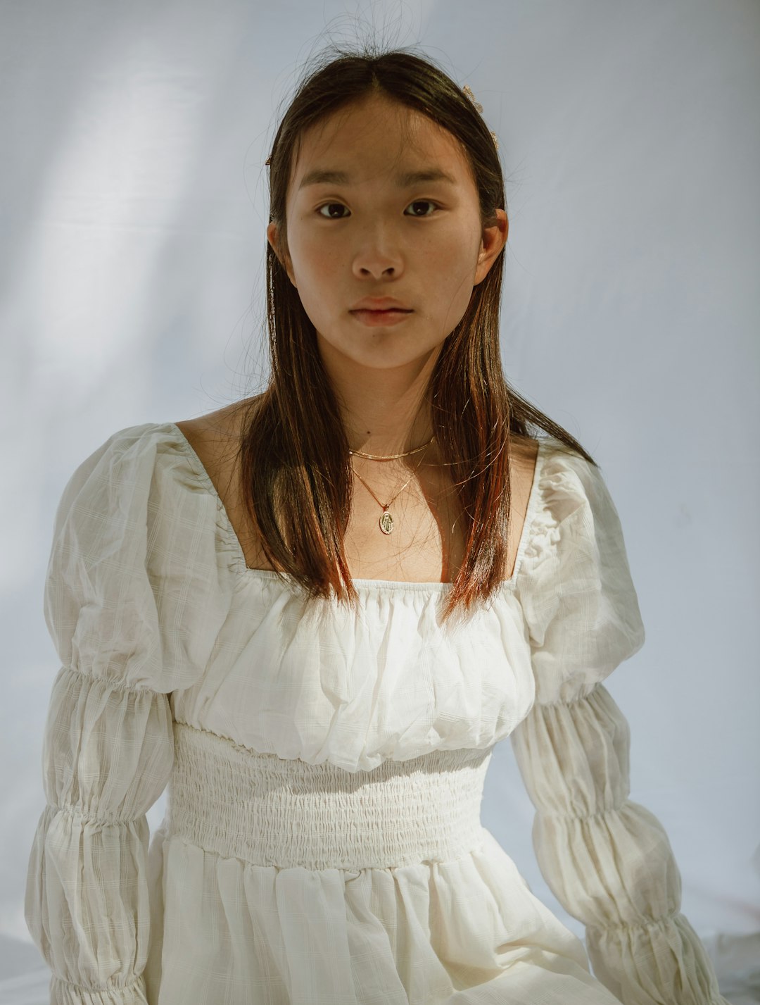 girl in white dress wearing silver necklace