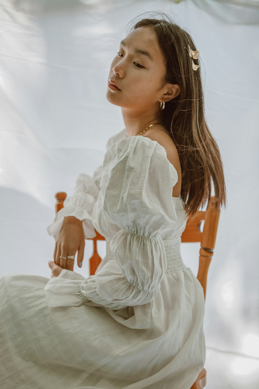 woman in white dress sitting on bed