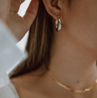 woman in white shirt wearing gold necklace