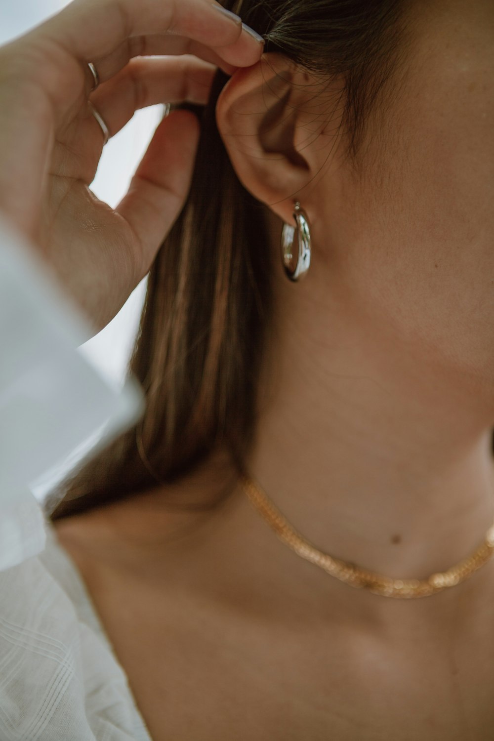 Mujer en camisa blanca con collar de oro