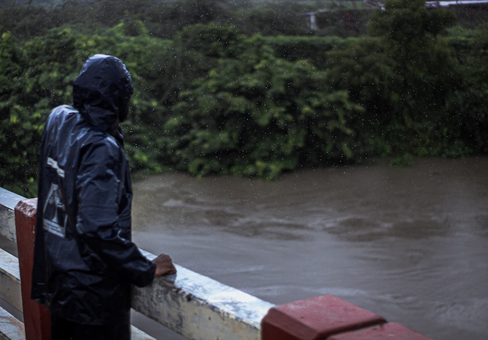 man in black jacket standing near body of water during daytime