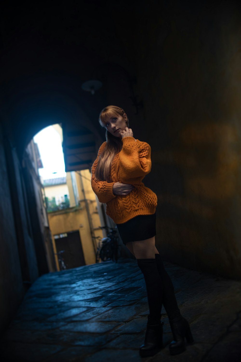 donna in maglione lavorato a maglia marrone e pantaloni neri in piedi sul corridoio