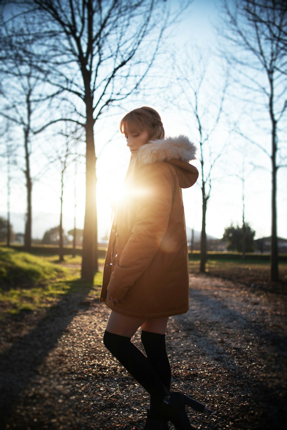 woman in white fur coat standing on pathway during daytime
