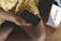 A person wearing a yellow dress with a small floral pattern holds a black smartphone. Beside them is a white box with the brand name 'Swappie' visible.