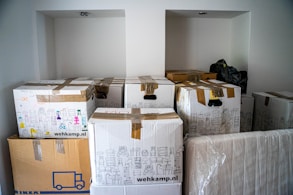 brown cardboard boxes being stored in a garage waiting to be picked up by a moving company