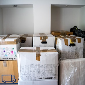 brown cardboard boxes being stored in a garage waiting to be picked up by a moving company