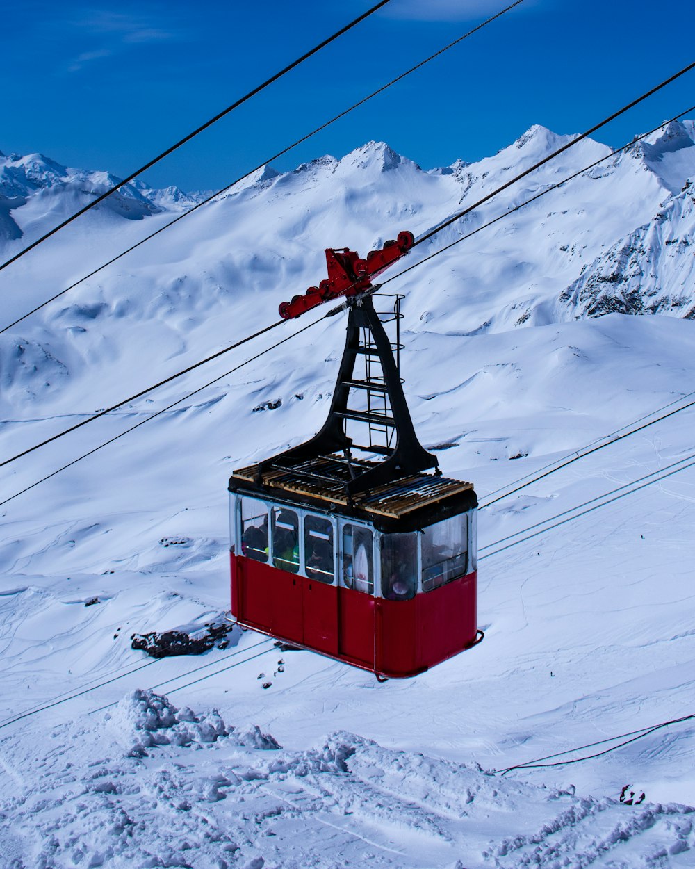 red and black cable car over snow covered ground