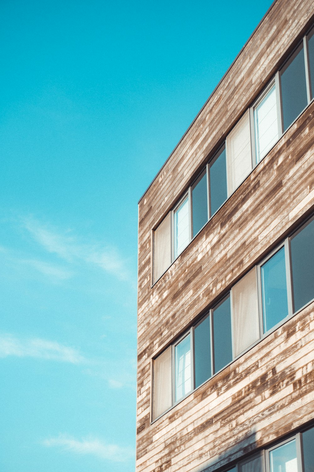 Edificio de hormigón marrón y blanco bajo el cielo azul durante el día