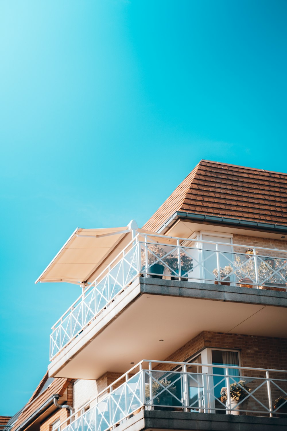 Edificio de hormigón blanco y marrón bajo el cielo azul durante el día