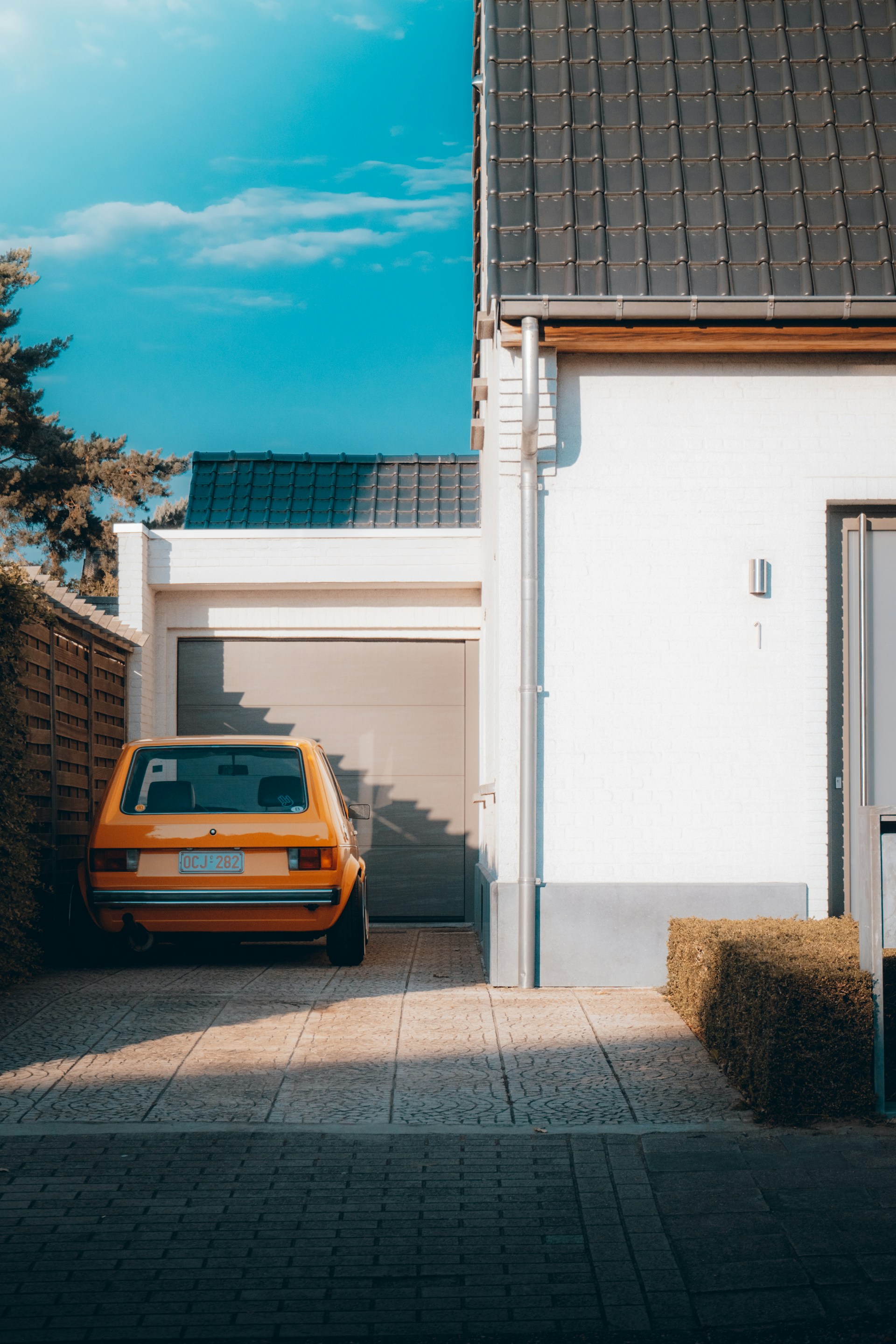 yellow car parked beside white building