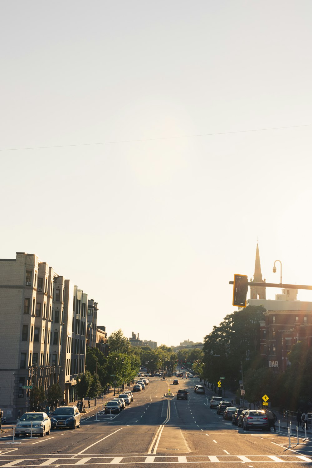 cars parked on side of the road near buildings during daytime