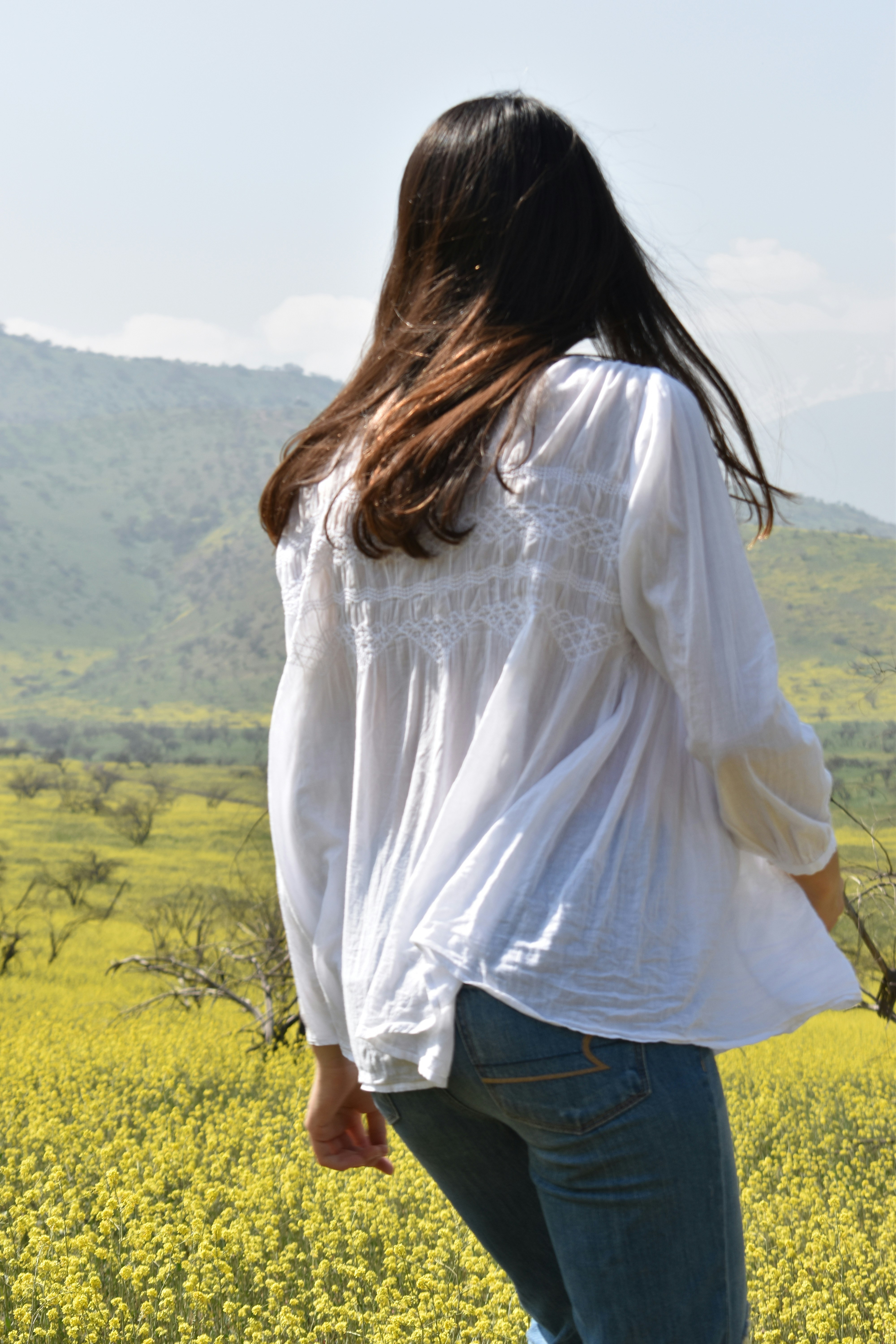 woman in white long sleeve shirt standing on green grass field during daytime