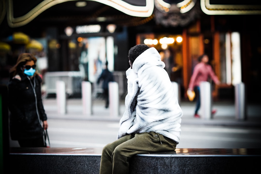 man in gray hoodie sitting on bench