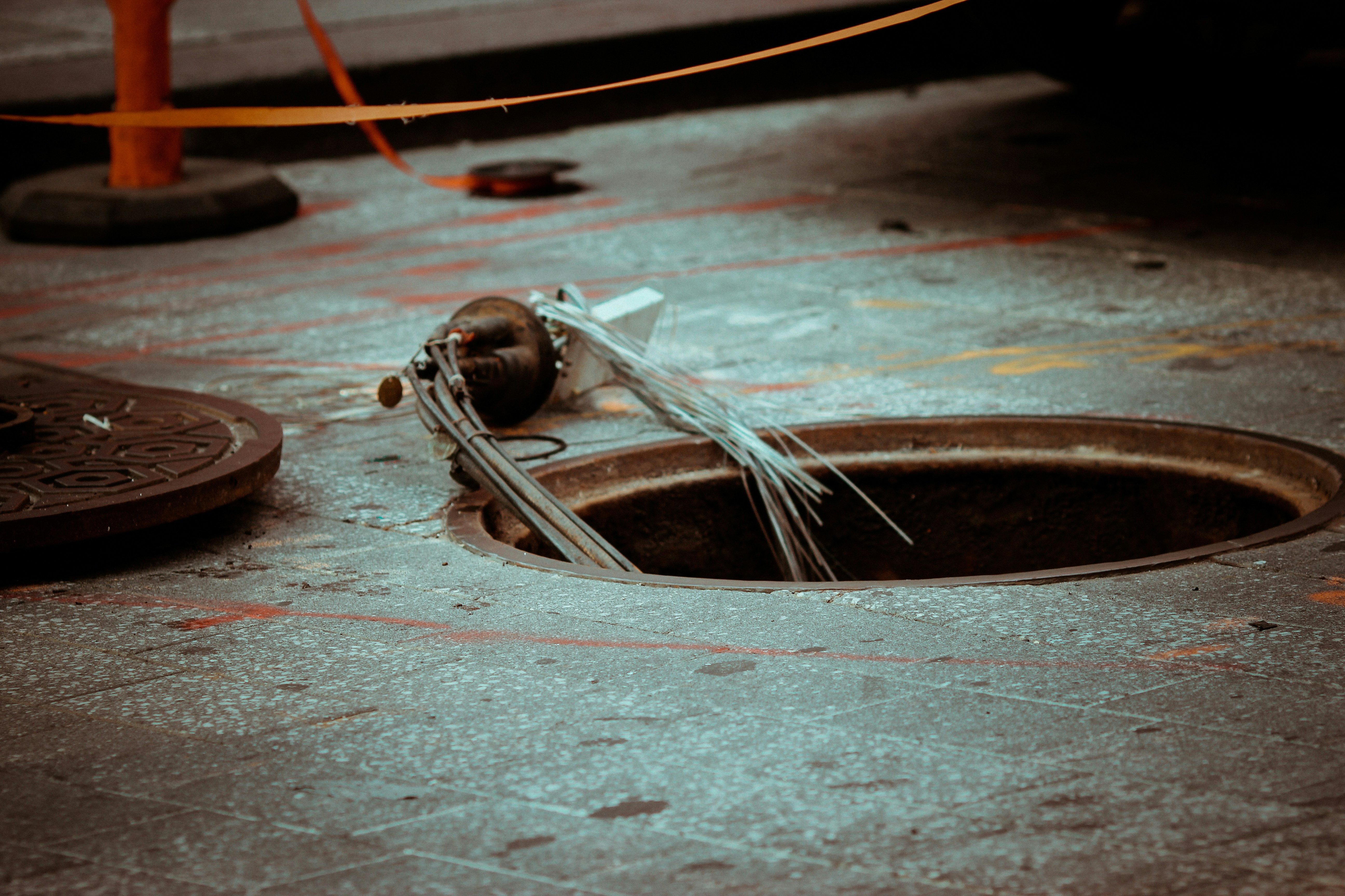 Engineer with safety gear inspecting red industrial piping system indoors.
