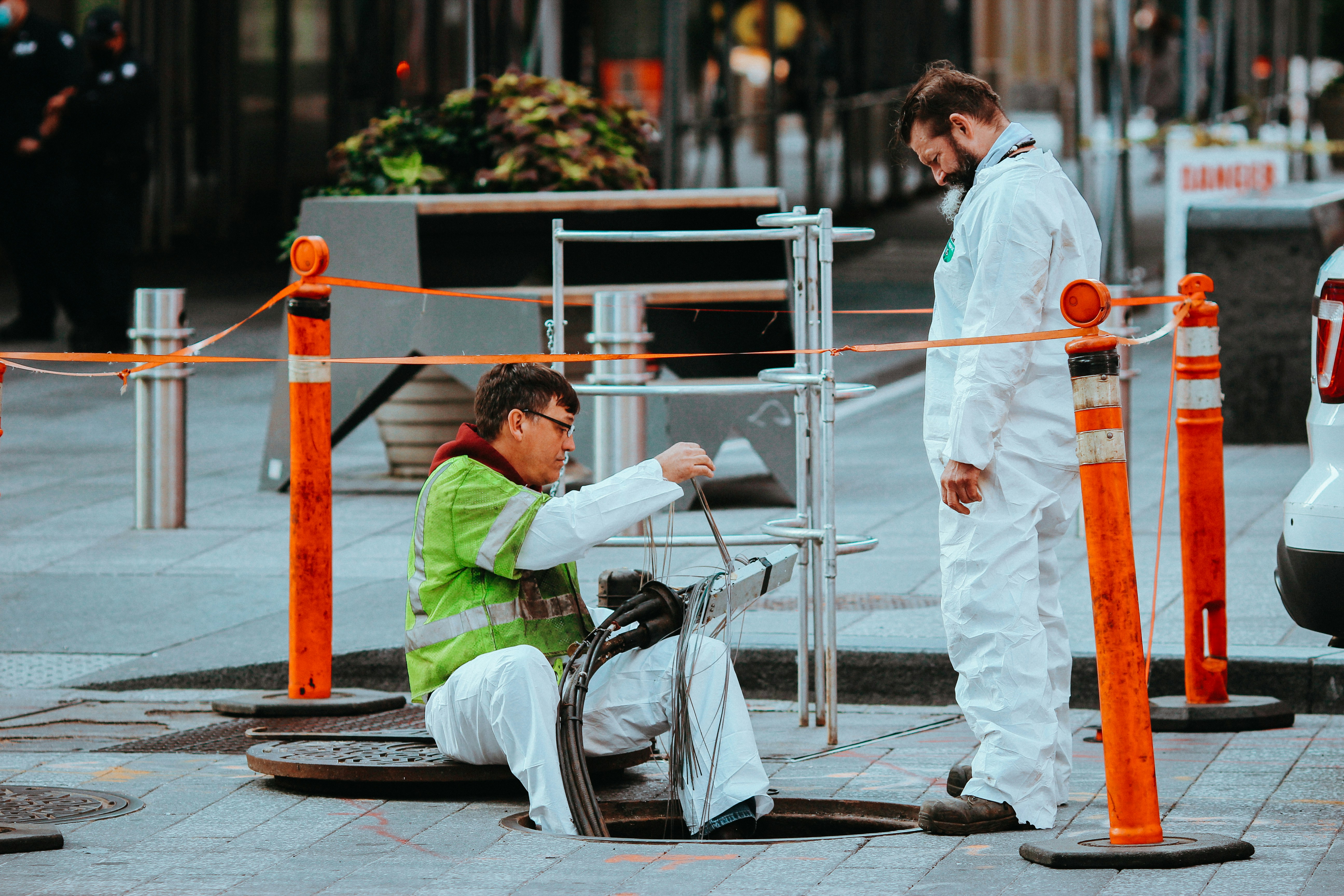 man in green shirt sitting on black motorcycle beside woman in white dress during daytime
