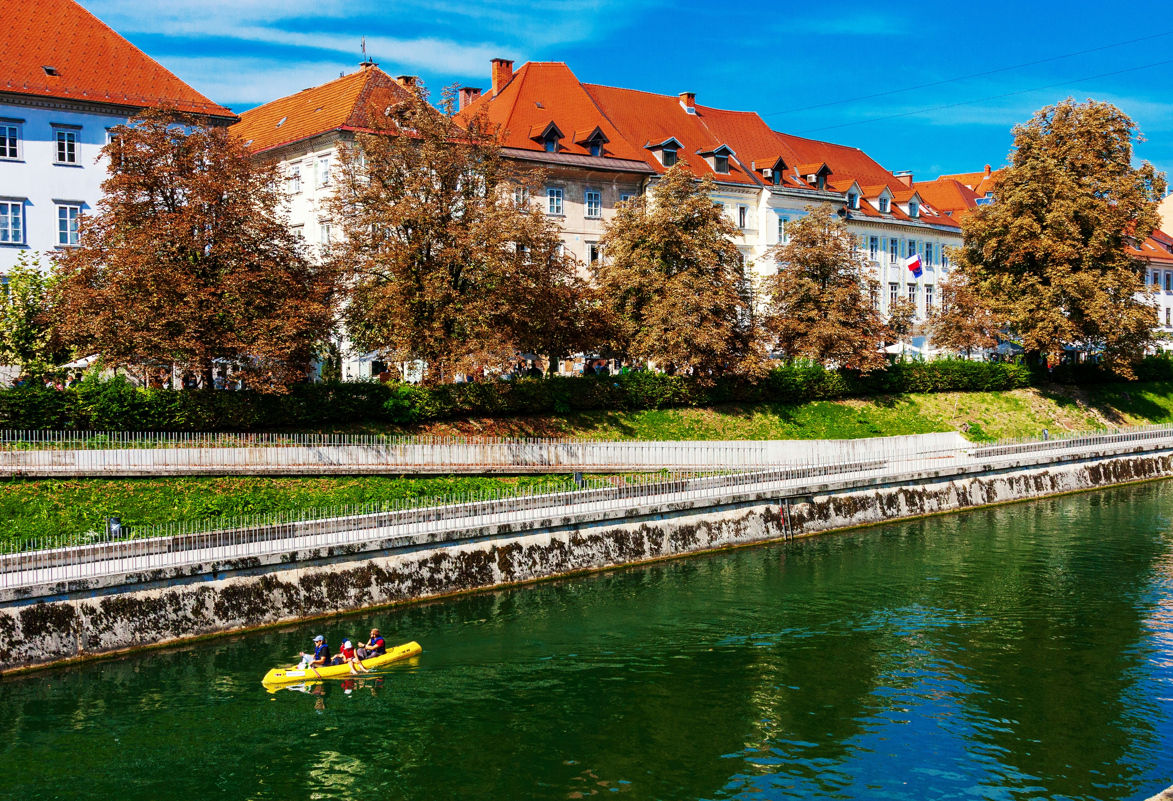 yellow kayak on river near brown concrete building during daytime
