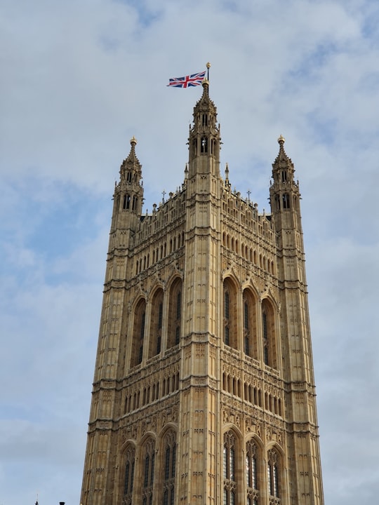 brown concrete building with flag of us a on top in Westminster Abbey United Kingdom