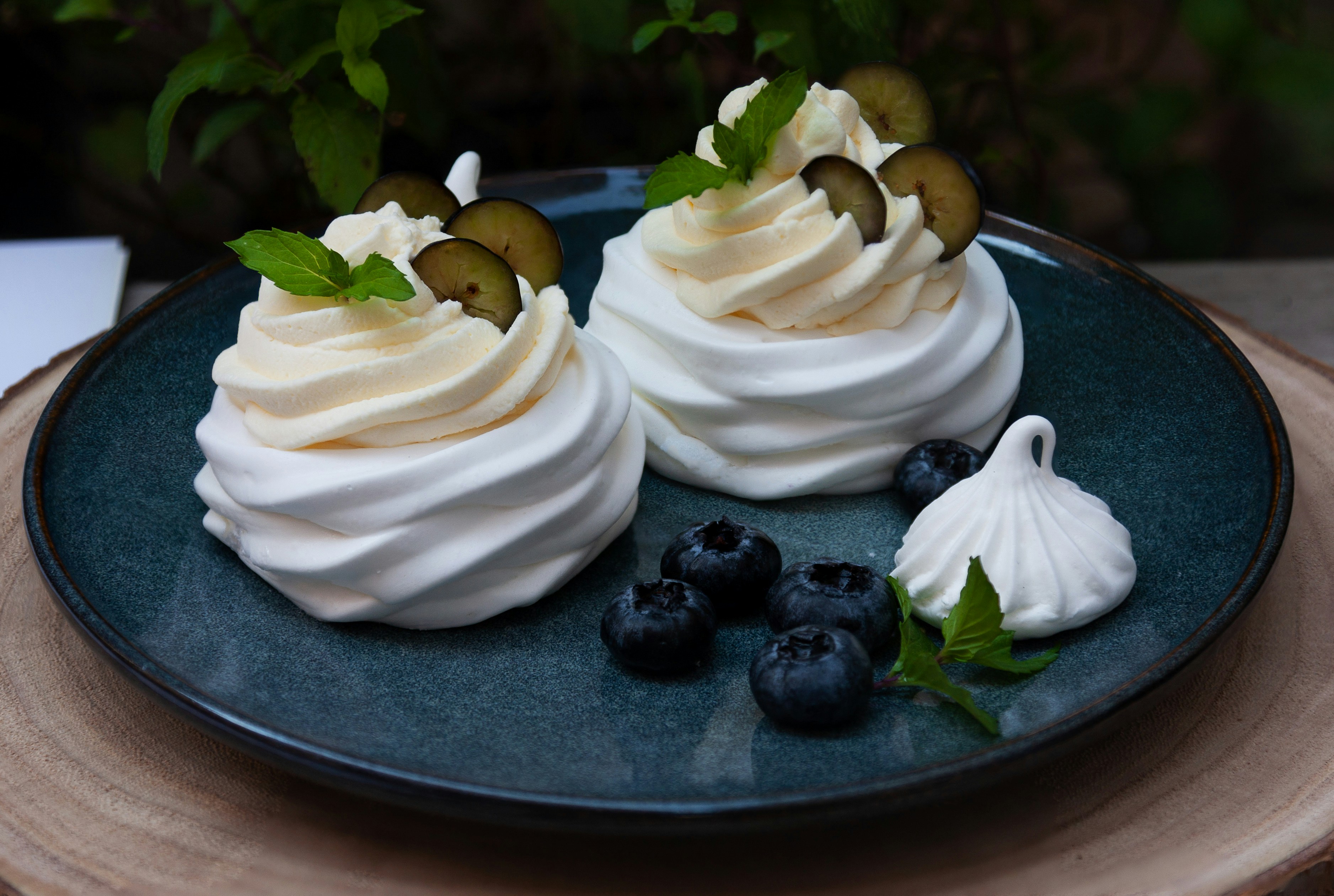 white icing covered cake with black berries on top