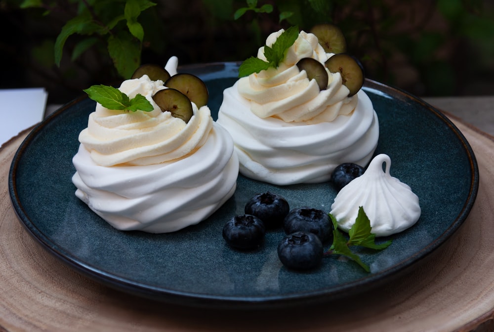 white icing covered cake with black berries on top
