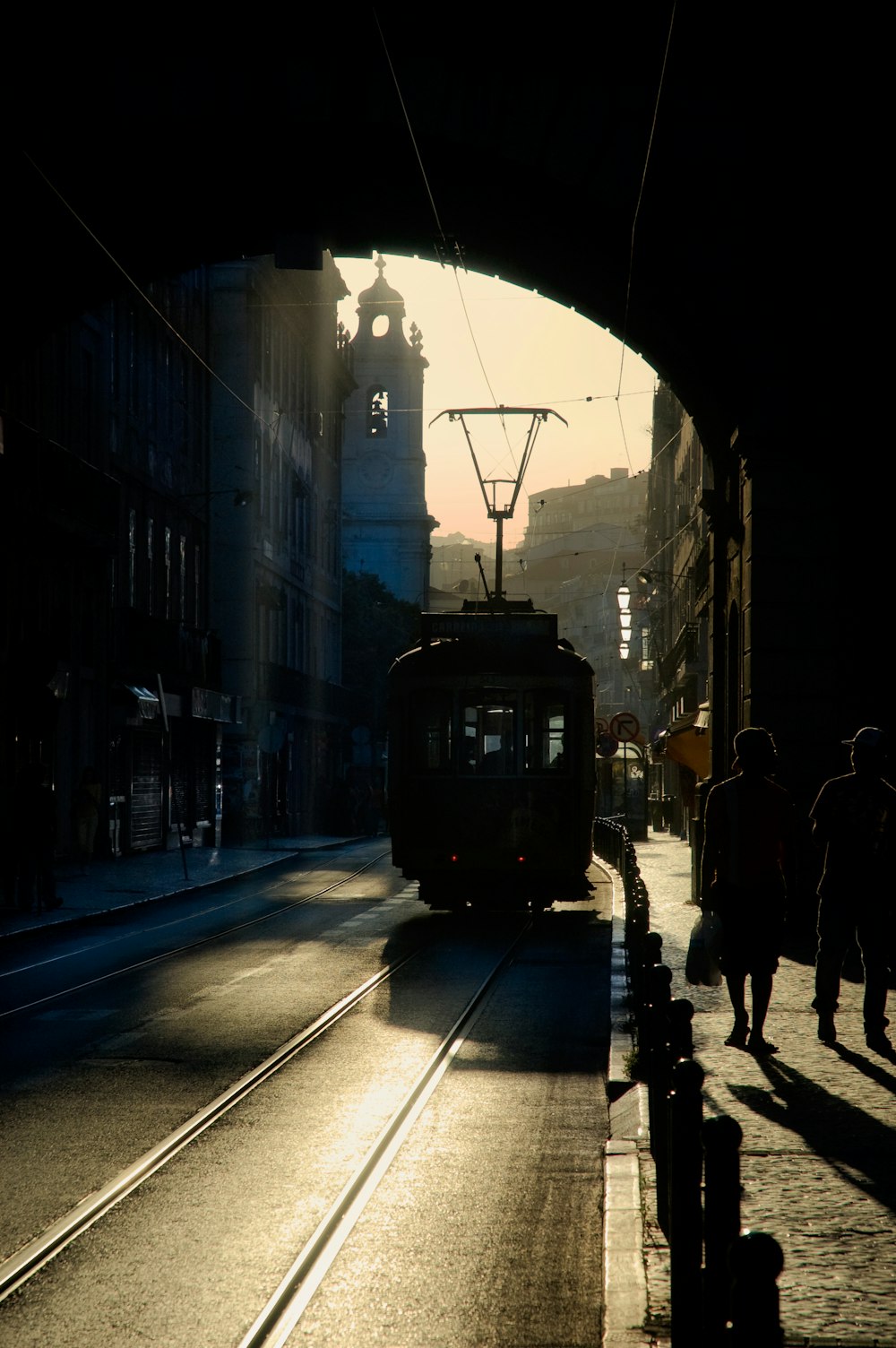 Personnes marchant sur le trottoir près du tramway noir pendant la nuit