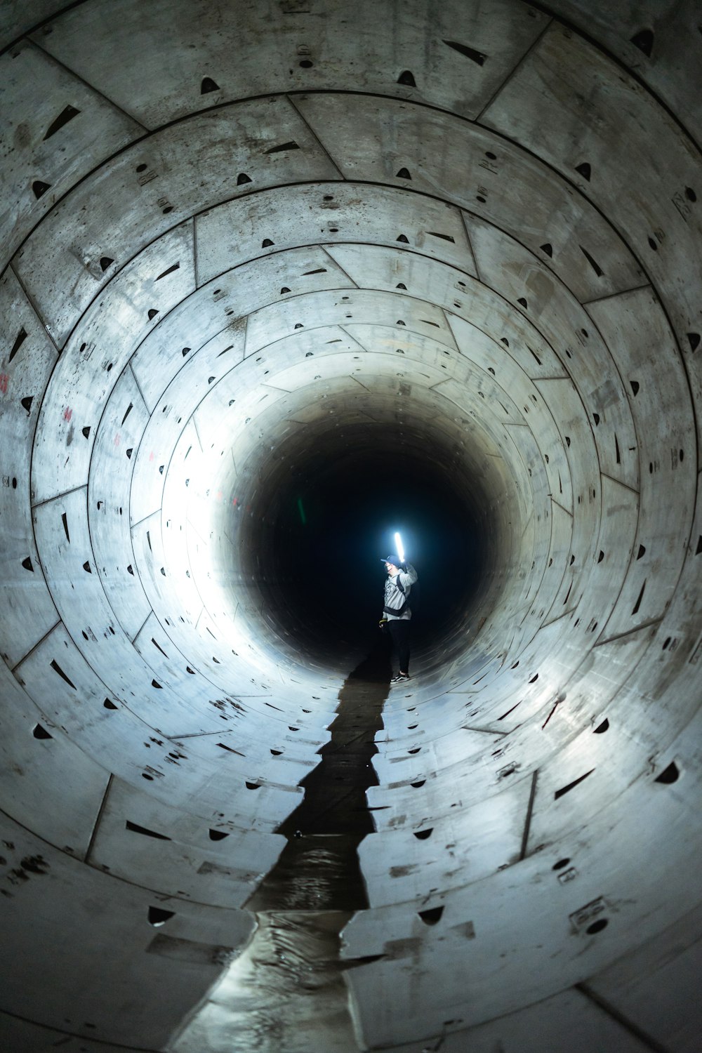 man in black jacket walking on tunnel