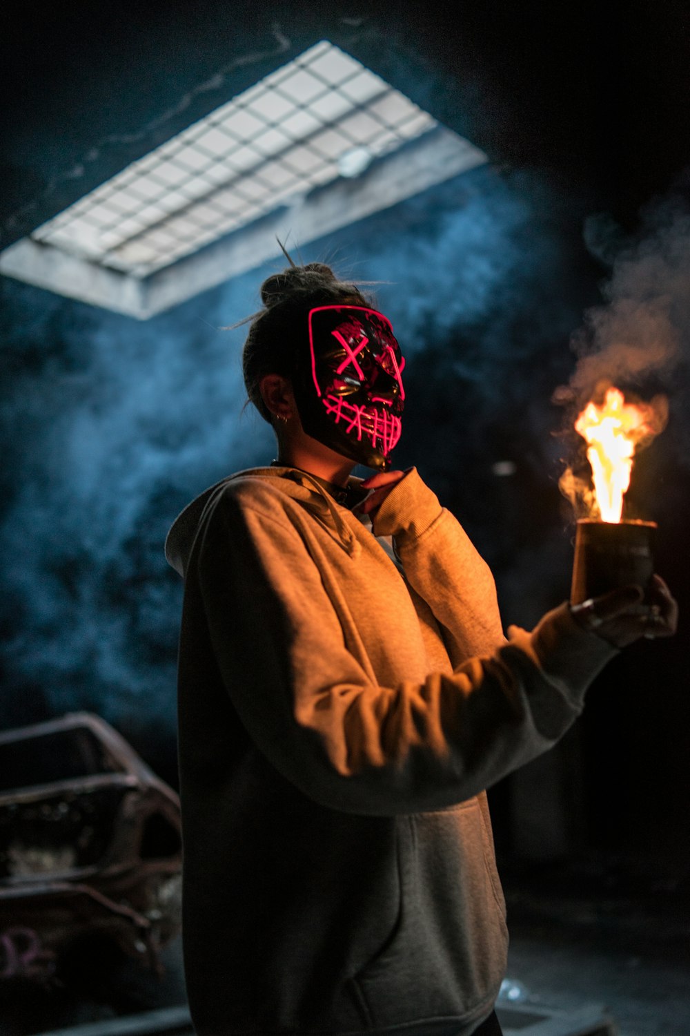 man in brown hoodie holding fire