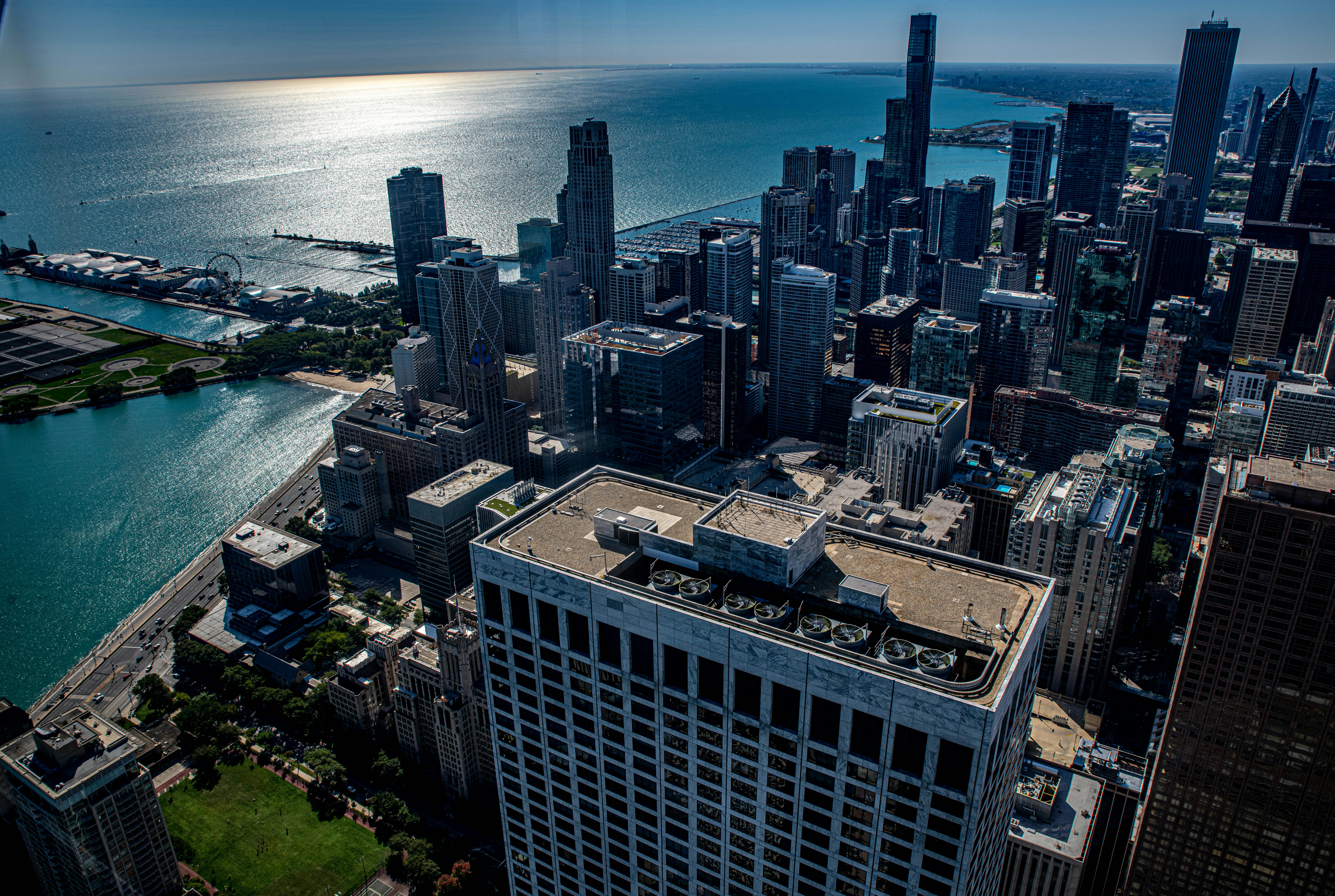 Aerial view of Chicago city skyline, bright daytime, Lake Michigan visible, clear blue sky