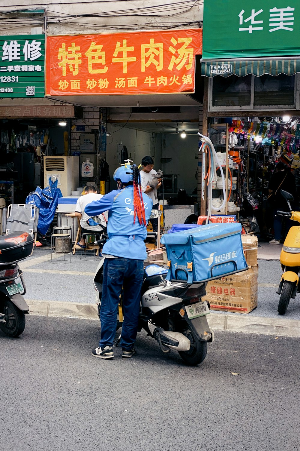 a man standing next to a scooter on a street