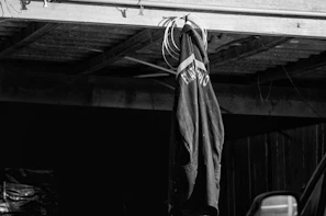 Black and white photo of a sleek, minimalistic sports jacket hanging on a simple rack.