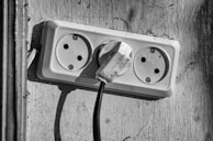 Close-up of hands repairing an electrical outlet inside a home.