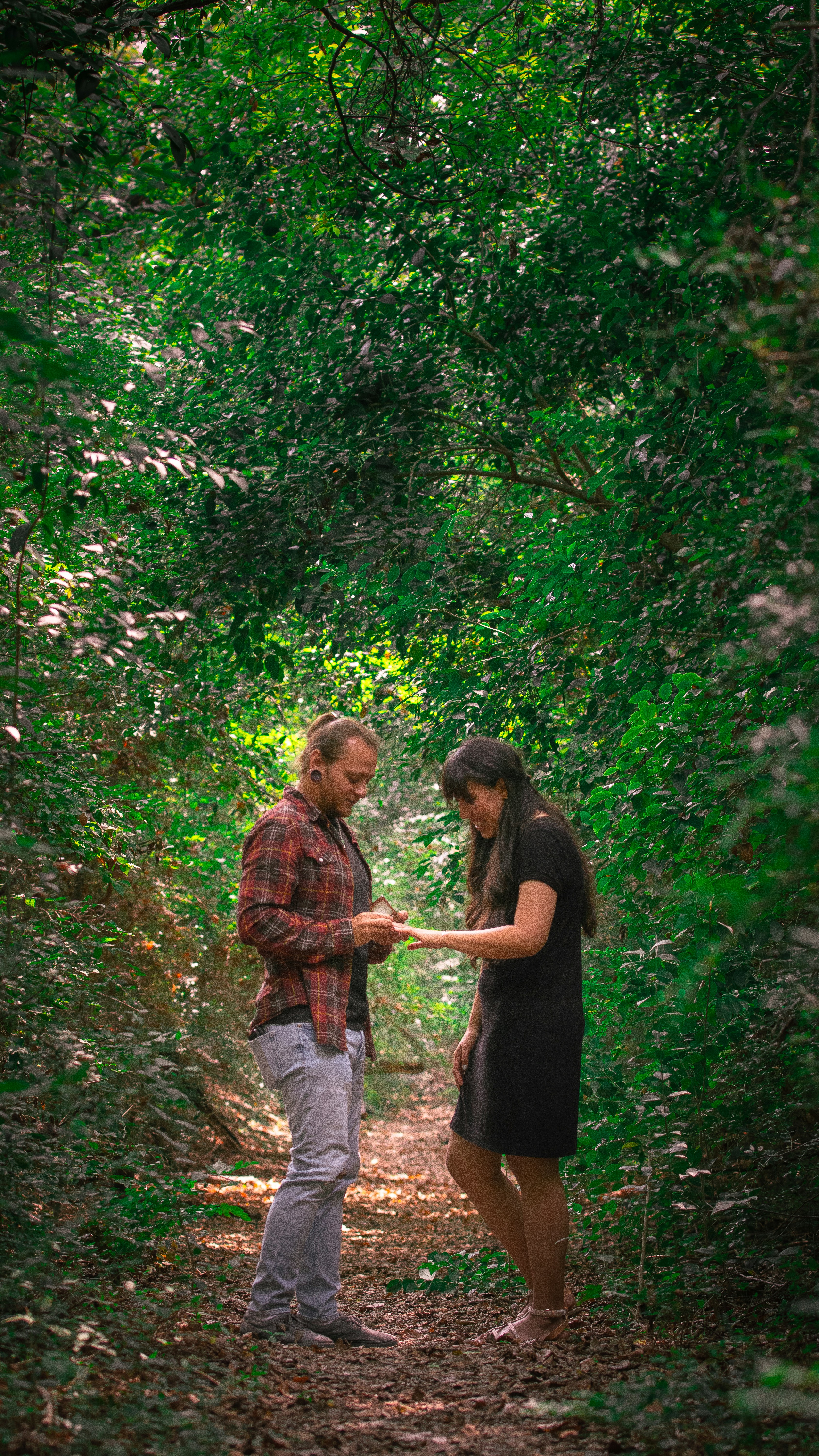 man and woman walking on forest during daytime