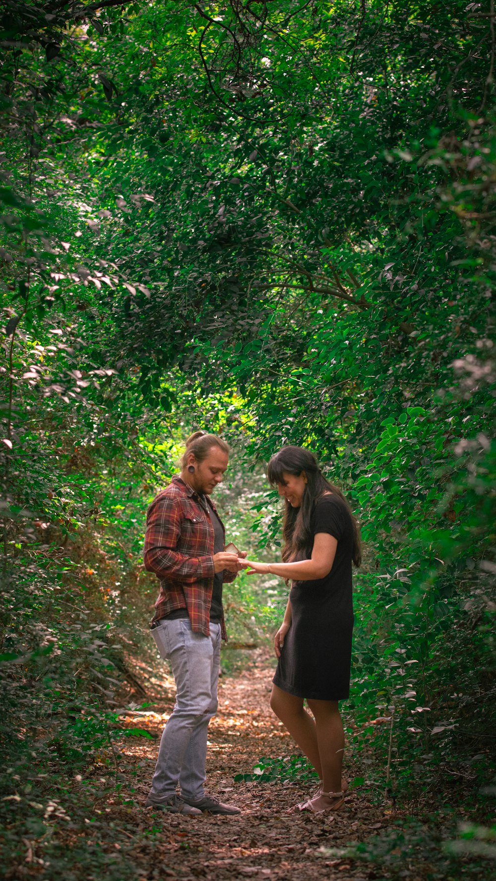 man and woman walking on forest during daytime