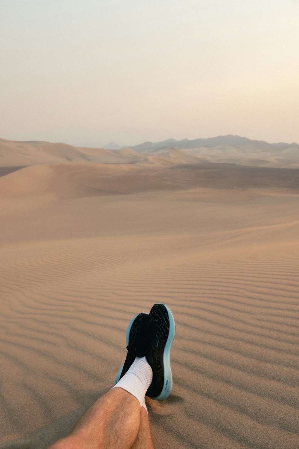 person in black pants walking on desert during daytime