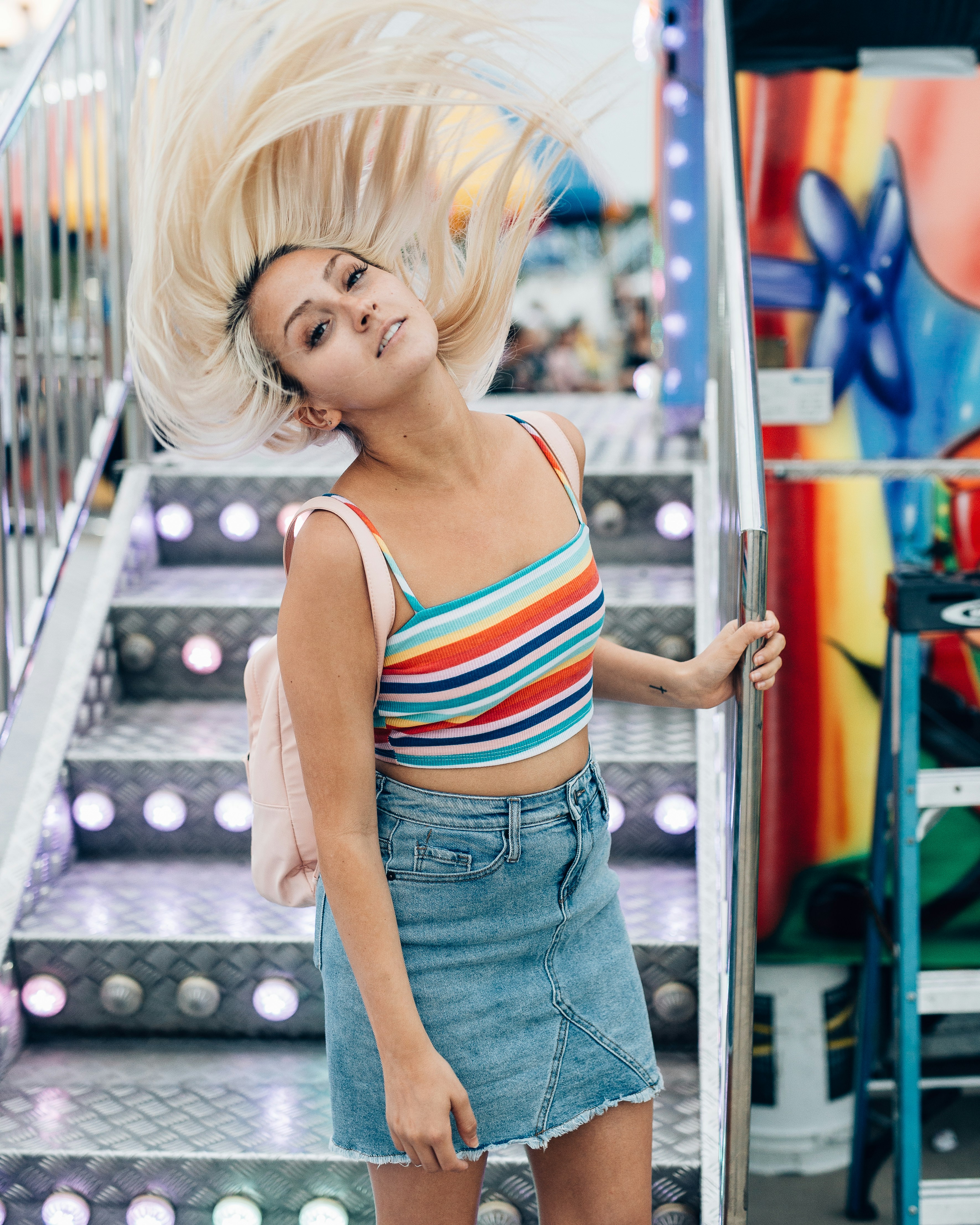 woman in white and red striped tank top and blue denim jeans
