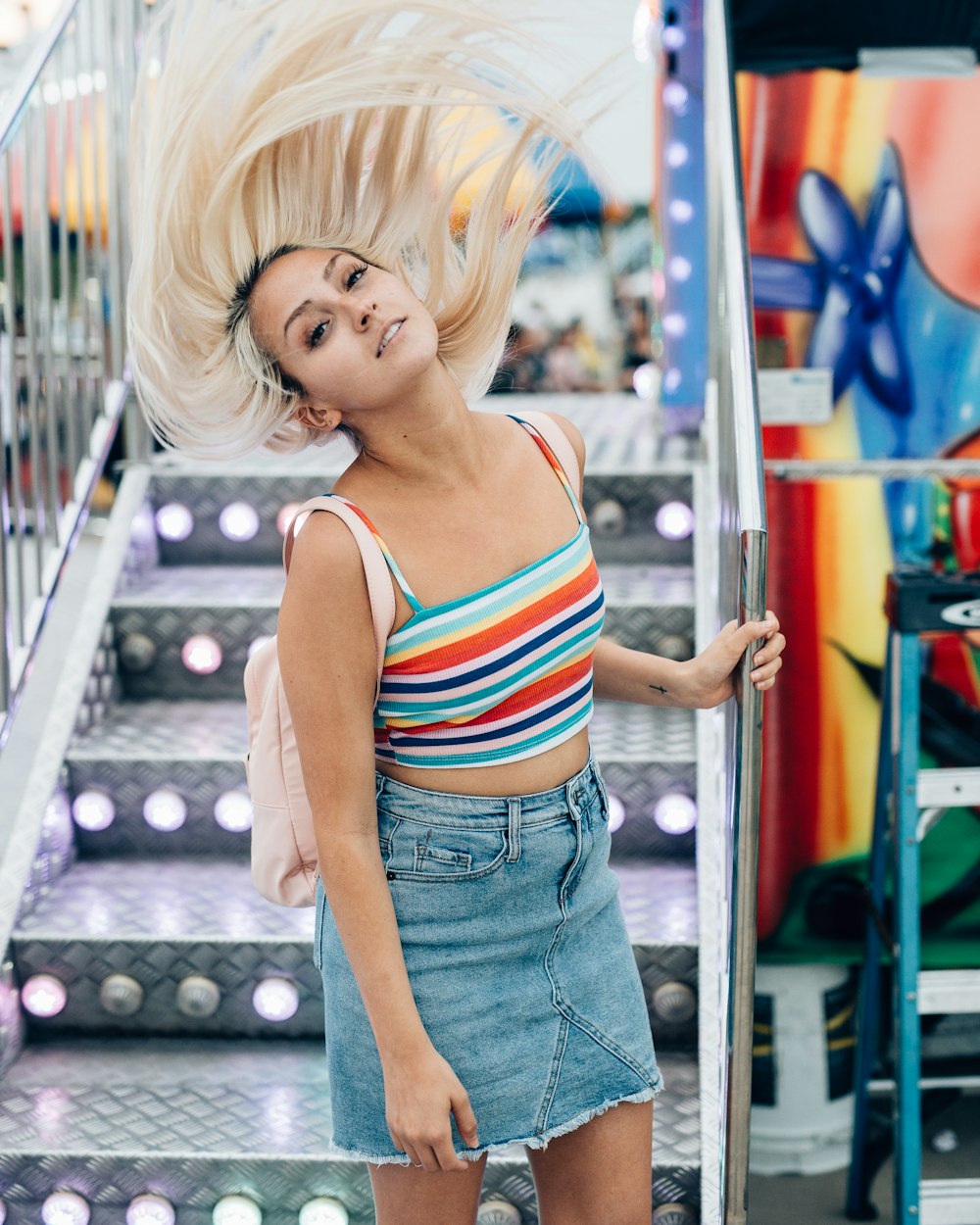 woman in white and red striped tank top and blue denim jeans