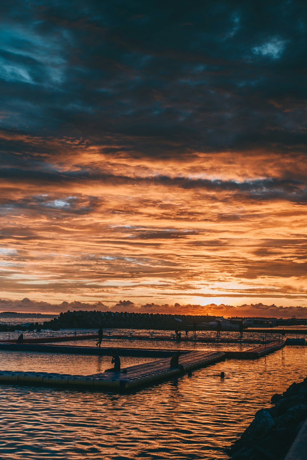 brown wooden dock on body of water during sunset