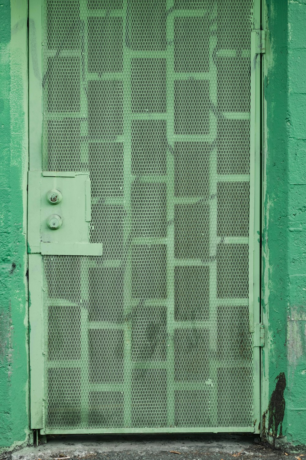 green wooden door with green steel door lever