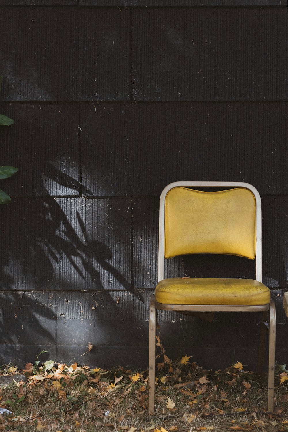 brown and gray chair beside black wall