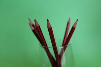 A set of sharpened pencils arranged in a cup on a study table.
